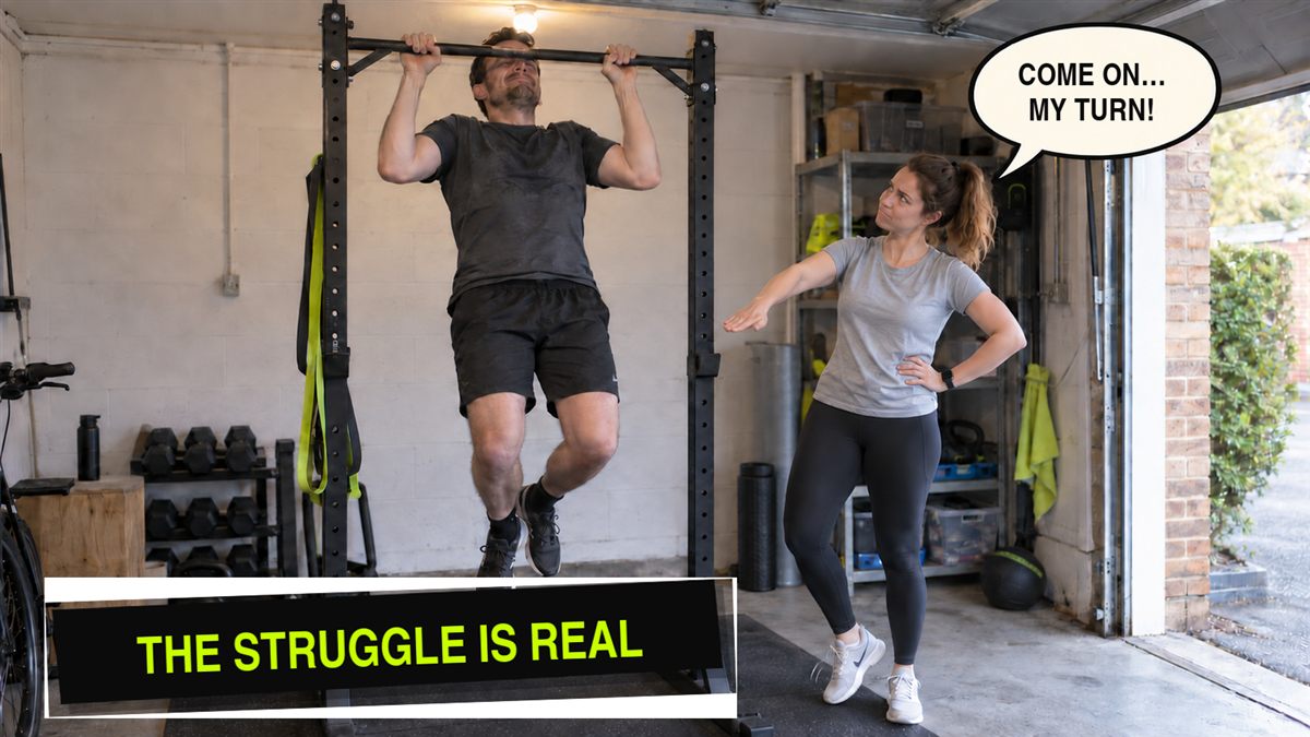 Someone hanging from a pull-up bar mid-attempt